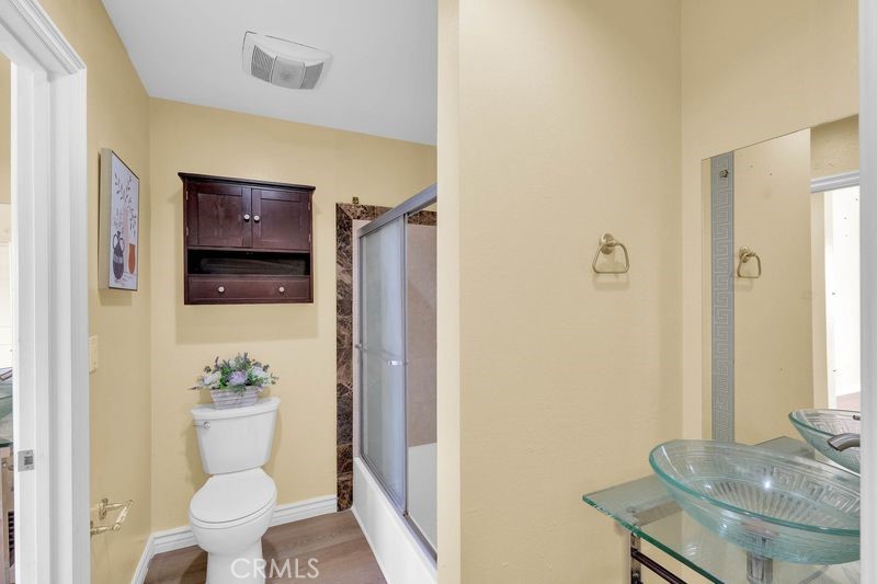 1781 Neil Armstrong Street, Unit 112 Montebello, CA 90640 - Photo 10 of 19 a bathroom with a granite countertop sink a toilet a mirror and shower