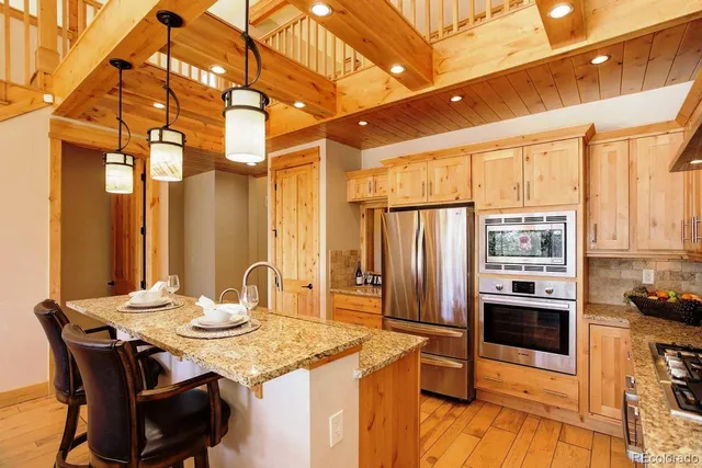 a kitchen with stainless steel appliances granite countertop a sink a stove and refrigerator
