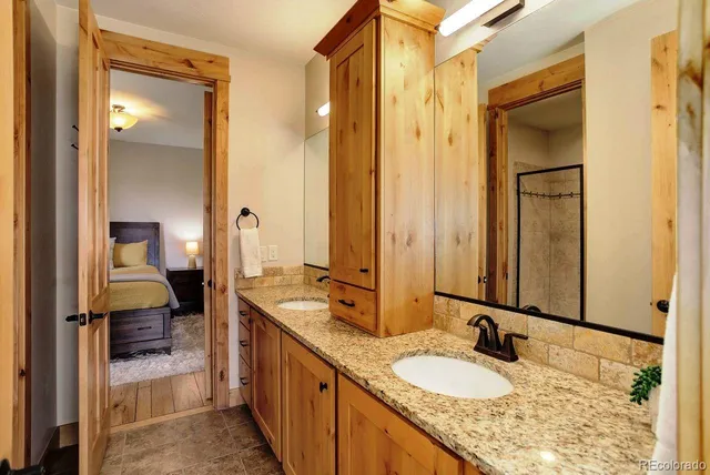 a en suite bathroom with a granite countertop sink and a mirror