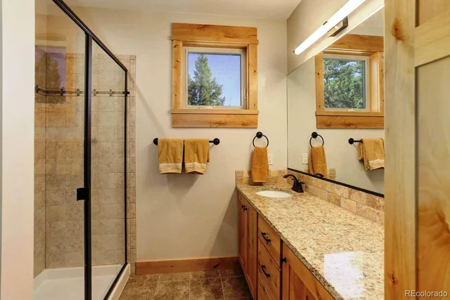 a bathroom with a granite countertop sink and a mirror