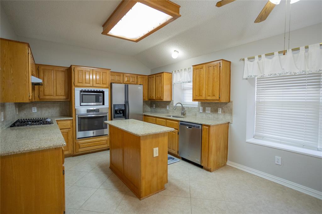 809 Sterling Court Allen, TX 75002 - Photo 15 of 16 a large kitchen with stainless steel appliances granite countertop a stove a sink and a refrigerator