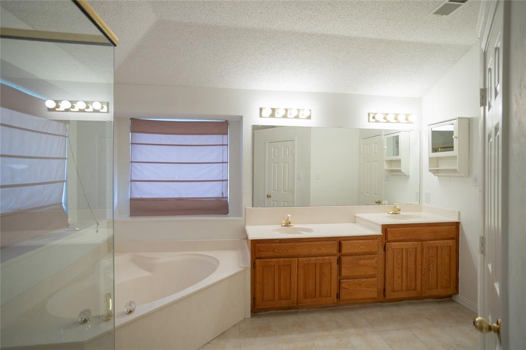 809 Sterling Court Allen, TX 75002 - Photo 3 of 16 a bathroom with a tub a sink and mirror
