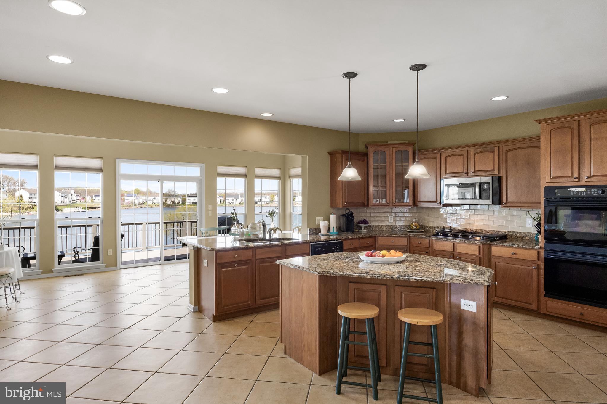 23 Mullen Drive Sicklerville, NJ 08081 - Photo 17 of 73 a kitchen with stainless steel appliances granite countertop a stove a sink a oven a dining table chairs and white cabinets