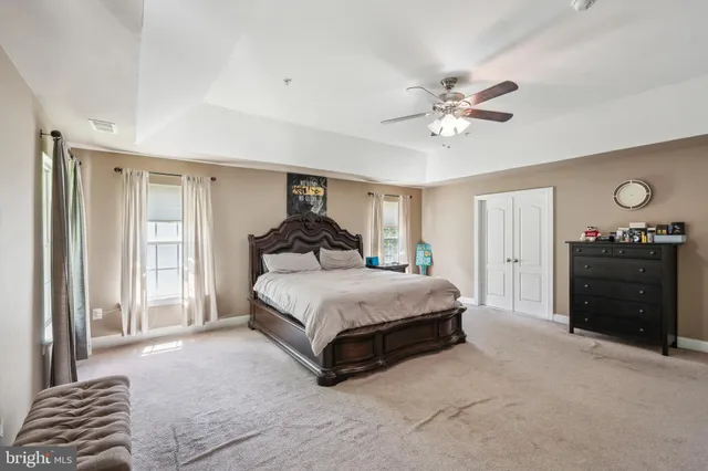 a spacious bedroom with a bed and a chandelier