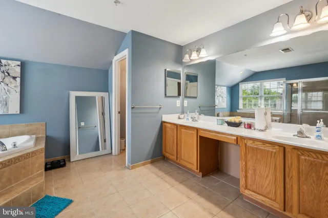 a large white kitchen with a sink window and cabinets