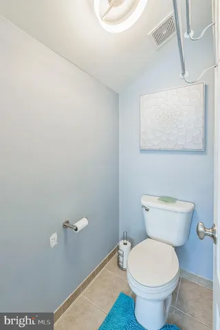 a toilet sitting in a bathroom next to a wooden wall