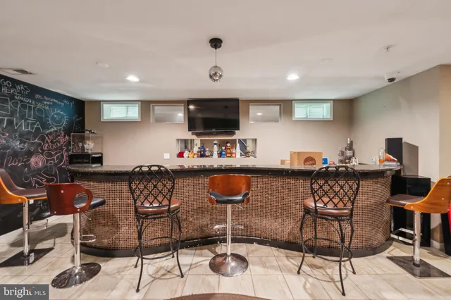 a living room with furniture a flat screen tv and kitchen view