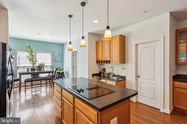 a kitchen with a table chairs stove and wooden floor