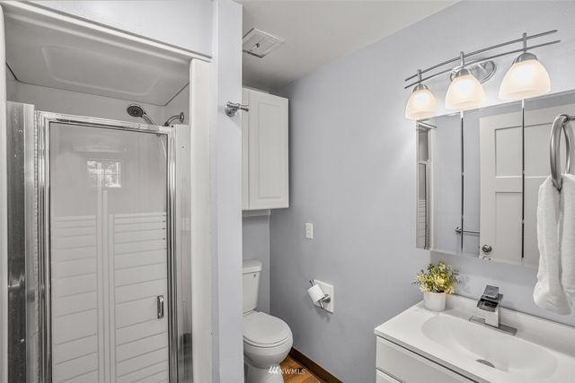 a bathroom with a sink a toilet and shower