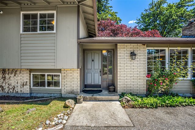 a view of a house with a large tree and a yard