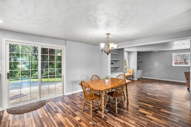 a view of a dining room with furniture a chandelier and wooden floor