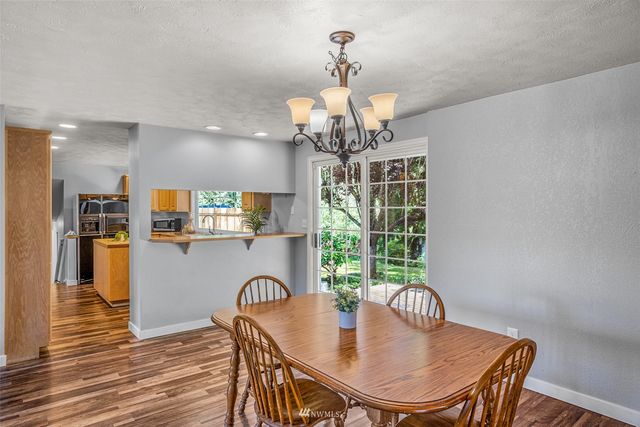 a dining room with furniture a chandelier and wooden floor