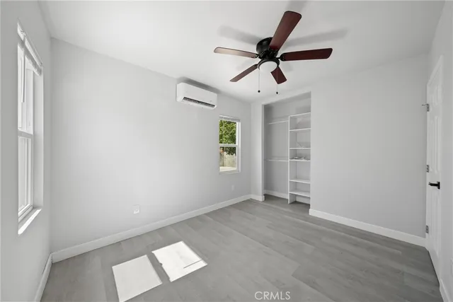 an empty room with closet and windows