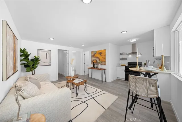 a living room with furniture and a dining table with kitchen view