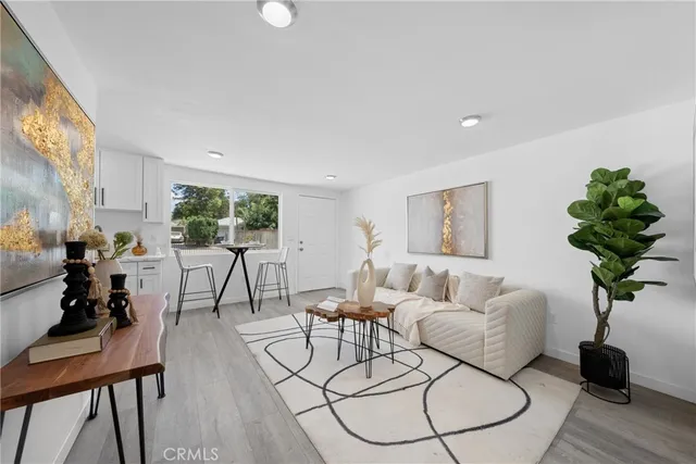 a living room with furniture a potted plant and a window