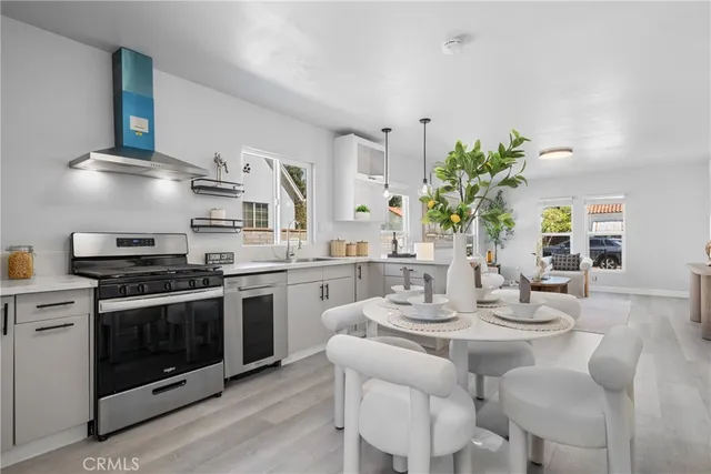 a kitchen with stainless steel appliances a white table and chairs in it