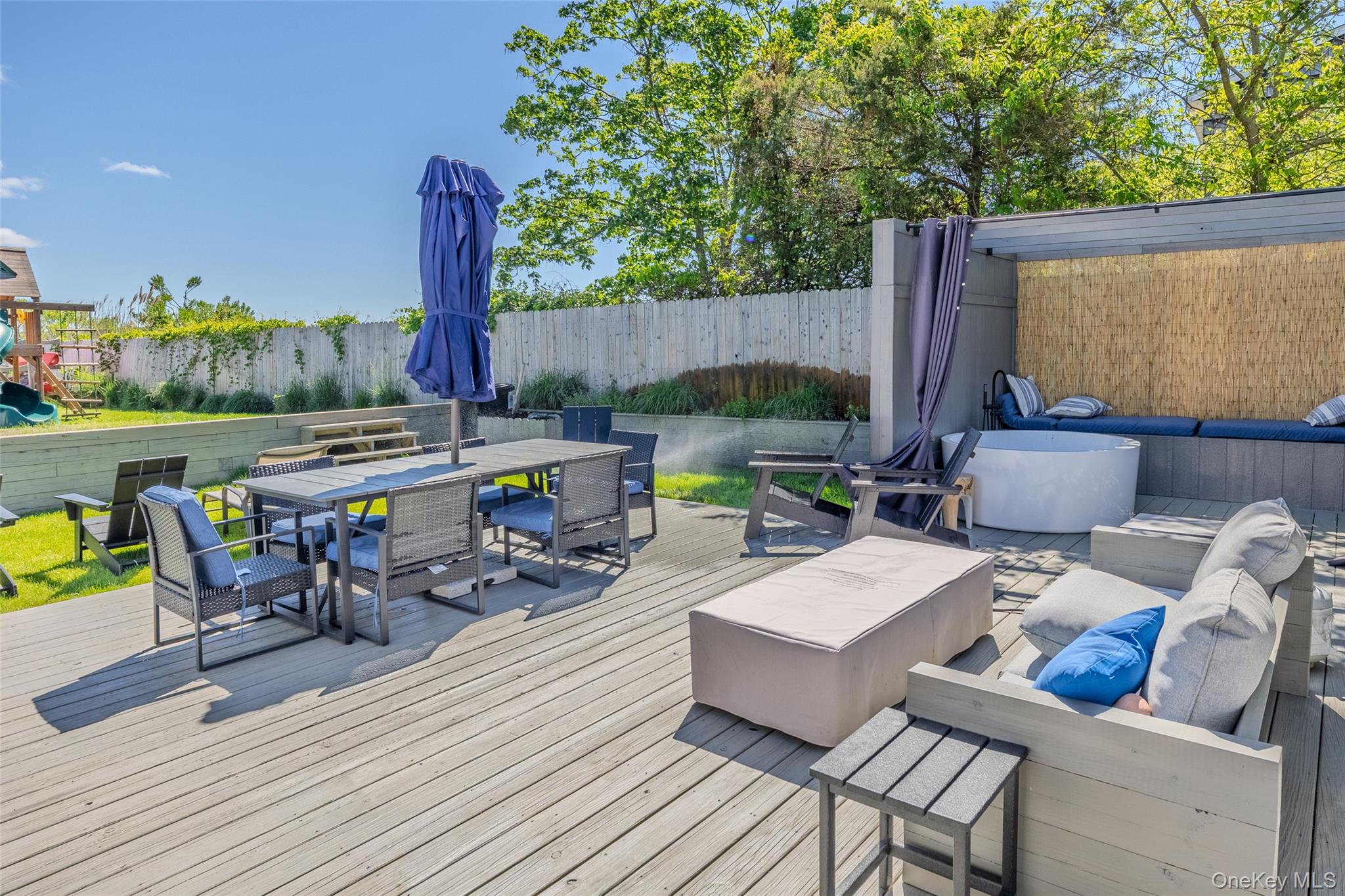 53 Old Neck Road South Center Moriches, NY 11934 - Photo 29 of 50 a view of deck with table and chairs couches with wooden floor and fence