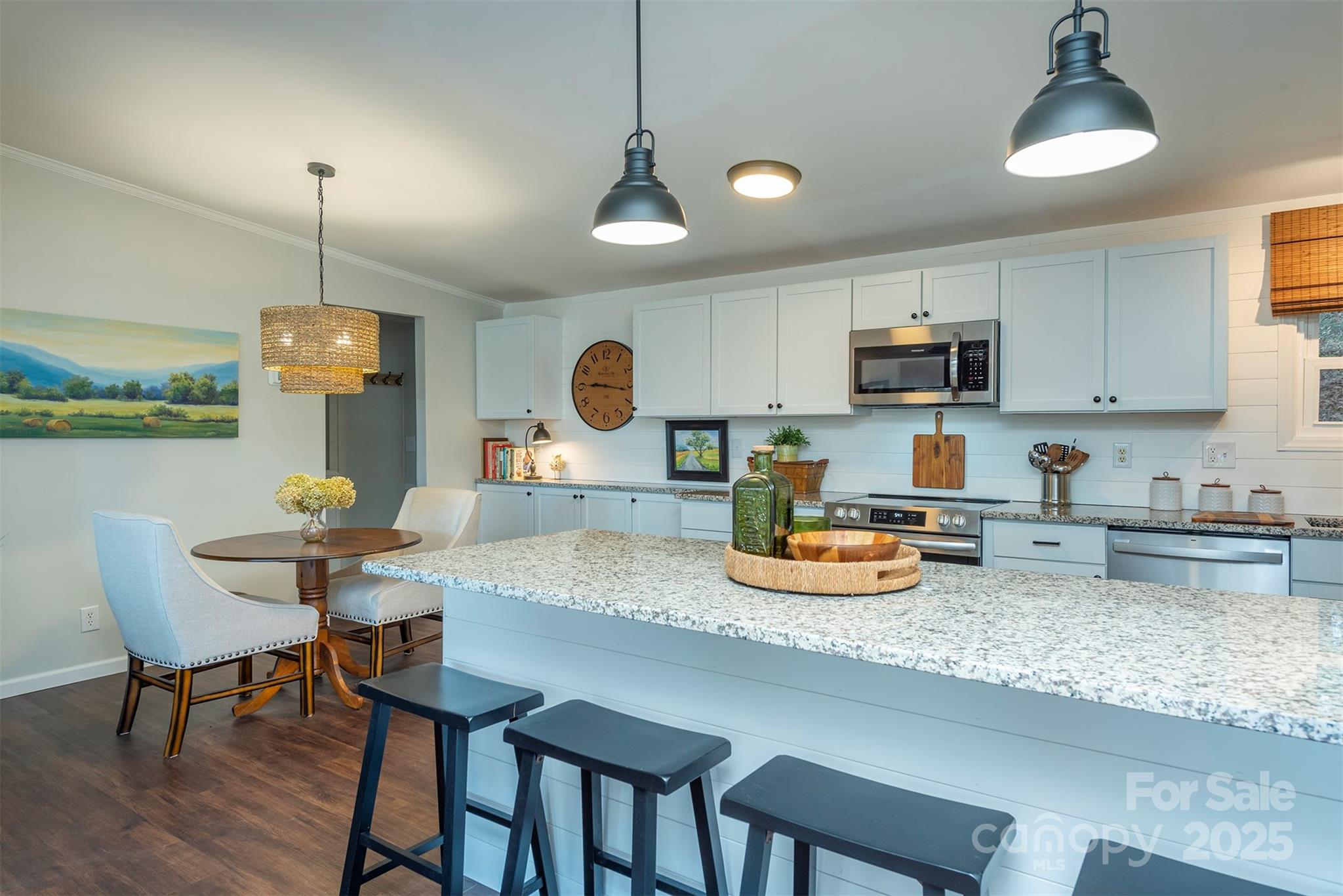 55 Whitaker Circle Fairview, NC 28730 - Photo 8 of 45 a kitchen with a sink a stove and chairs with wooden floor