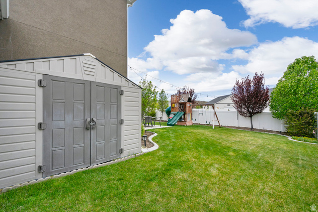 7685 Timber Country Road Eagle Mountain, UT 84005 - Photo 33 of 39 Expansive backyard featuring a green lawn, a white privacy fence, and mature trees