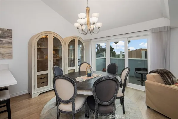 a dining room with furniture a chandelier and wooden floor