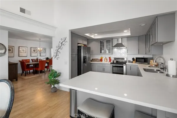 a kitchen with sink a refrigerator and chairs