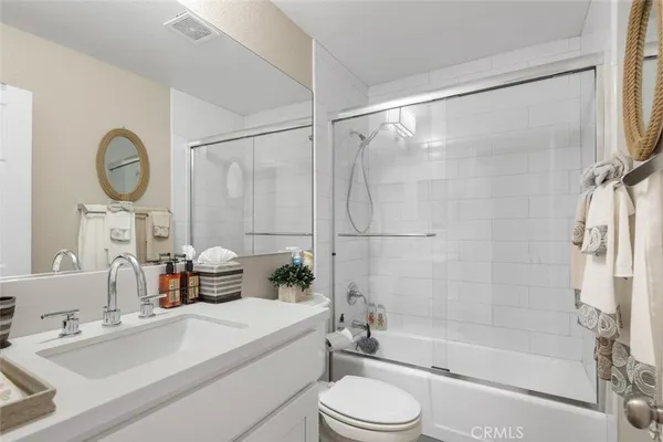 a bathroom with a bathtub shower sink vanity and toilet