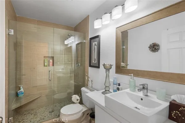 a bathroom with a sink a toilet and shower