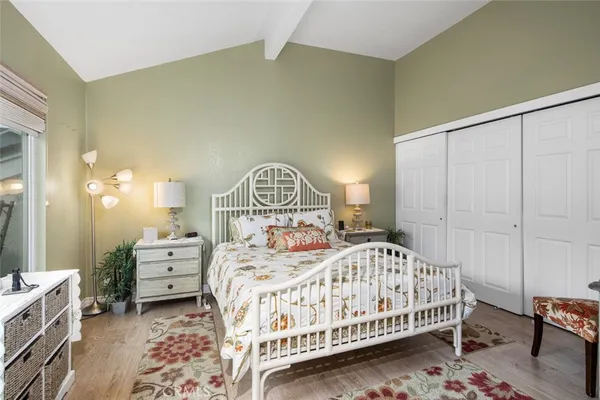 a bedroom with a bed a mirror on dresser and a table