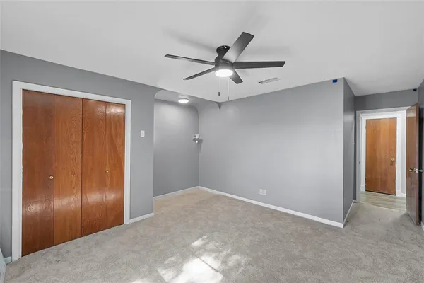 a view of a livingroom with a ceiling fan & entryway