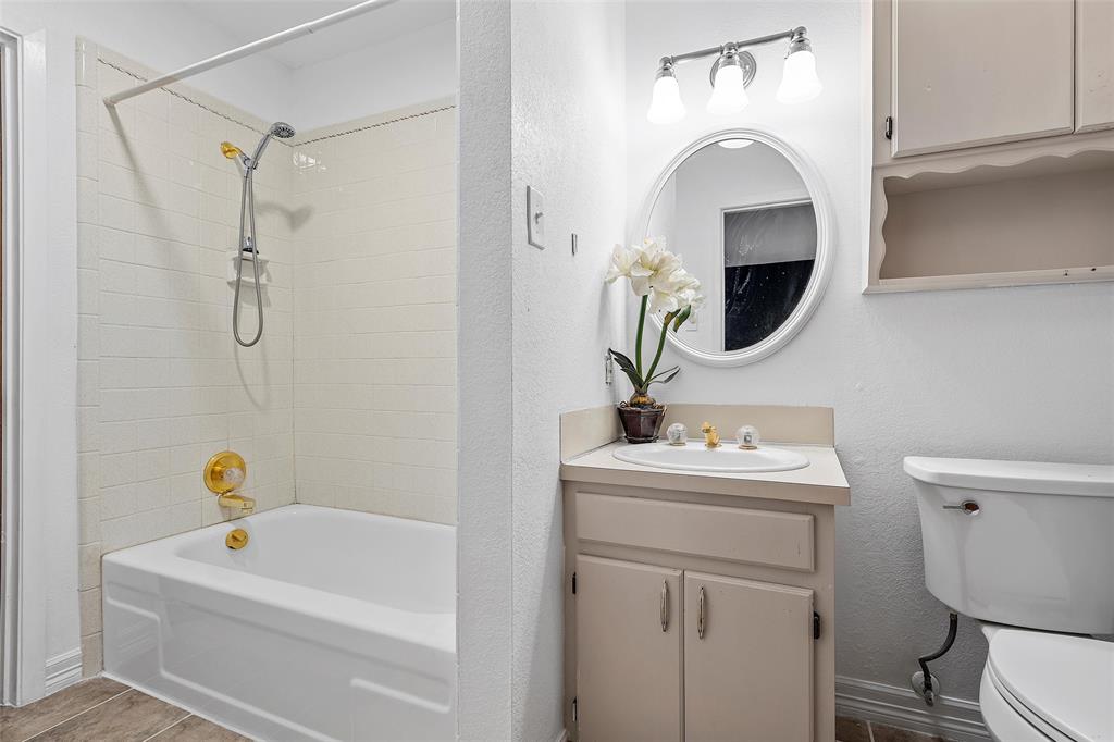544 Lusk Creek Road Eddy, TX 76524 - Photo 20 of 39 Bathroom with shower / tub combo, vanity, a textured wall, and dark tile patterned floors