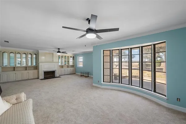 a view of an empty room with a fireplace and a window