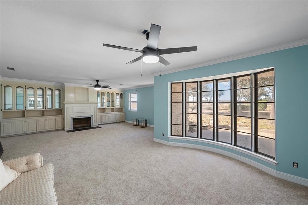 544 Lusk Creek Road Eddy, TX 76524 - Photo 4 of 39 Unfurnished living room featuring a fireplace with flush hearth, light colored carpet, and ornamental molding