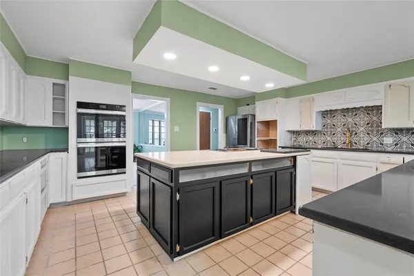 a large kitchen with stainless steel appliances granite countertop a large counter top and a stove