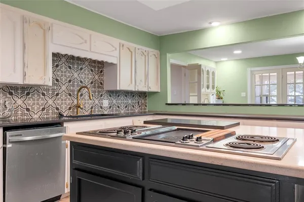 a kitchen with a stove and white cabinets