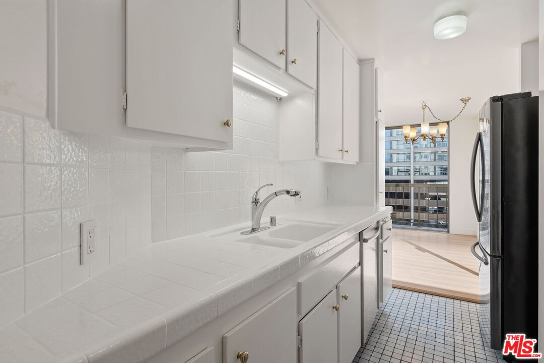 10747 Wilshire Boulevard, Unit 701 Los Angeles, CA 90024 - Photo 3 of 14 a kitchen with a sink appliances and cabinets