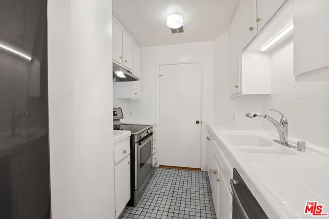 a kitchen with a sink stove and cabinets