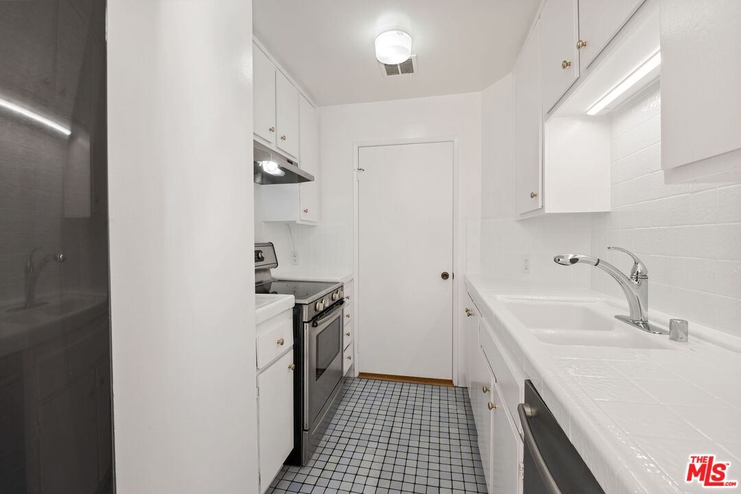 10747 Wilshire Boulevard, Unit 701 Los Angeles, CA 90024 - Photo 4 of 14 a kitchen with a sink stove and cabinets