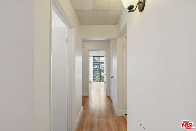 a view of a hallway with wooden floor