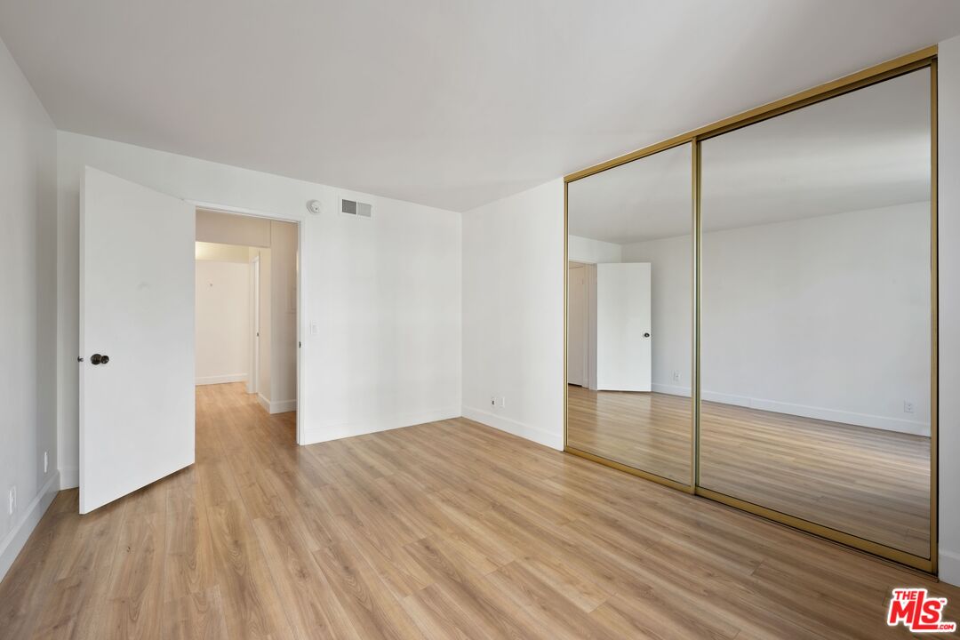 10747 Wilshire Boulevard, Unit 701 Los Angeles, CA 90024 - Photo 7 of 14 a view of an empty room with wooden floor and a bathroom