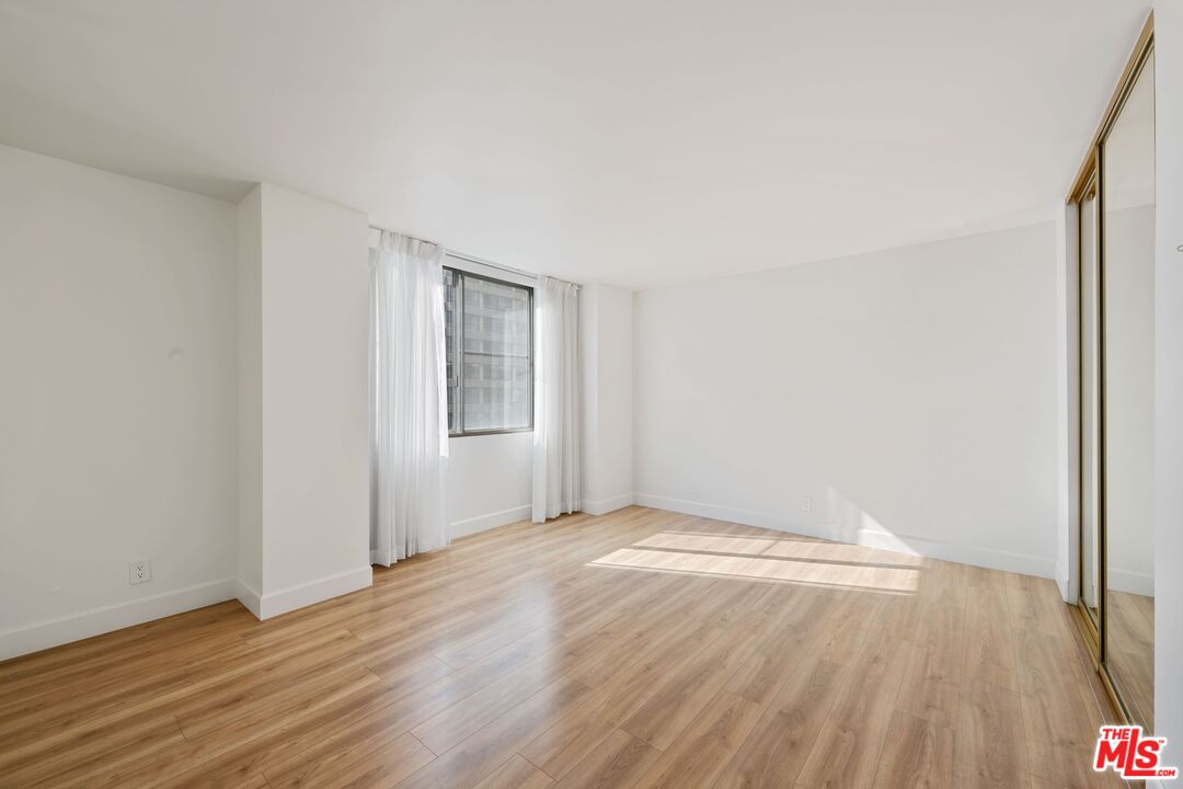 10747 Wilshire Boulevard, Unit 701 Los Angeles, CA 90024 - Photo 10 of 14 a view of an empty room with wooden floor