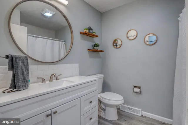 a bathroom with a toilet a sink and mirror