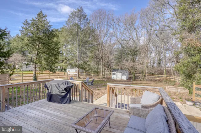 a view of a patio with dining table and chairs with wooden floor and fence