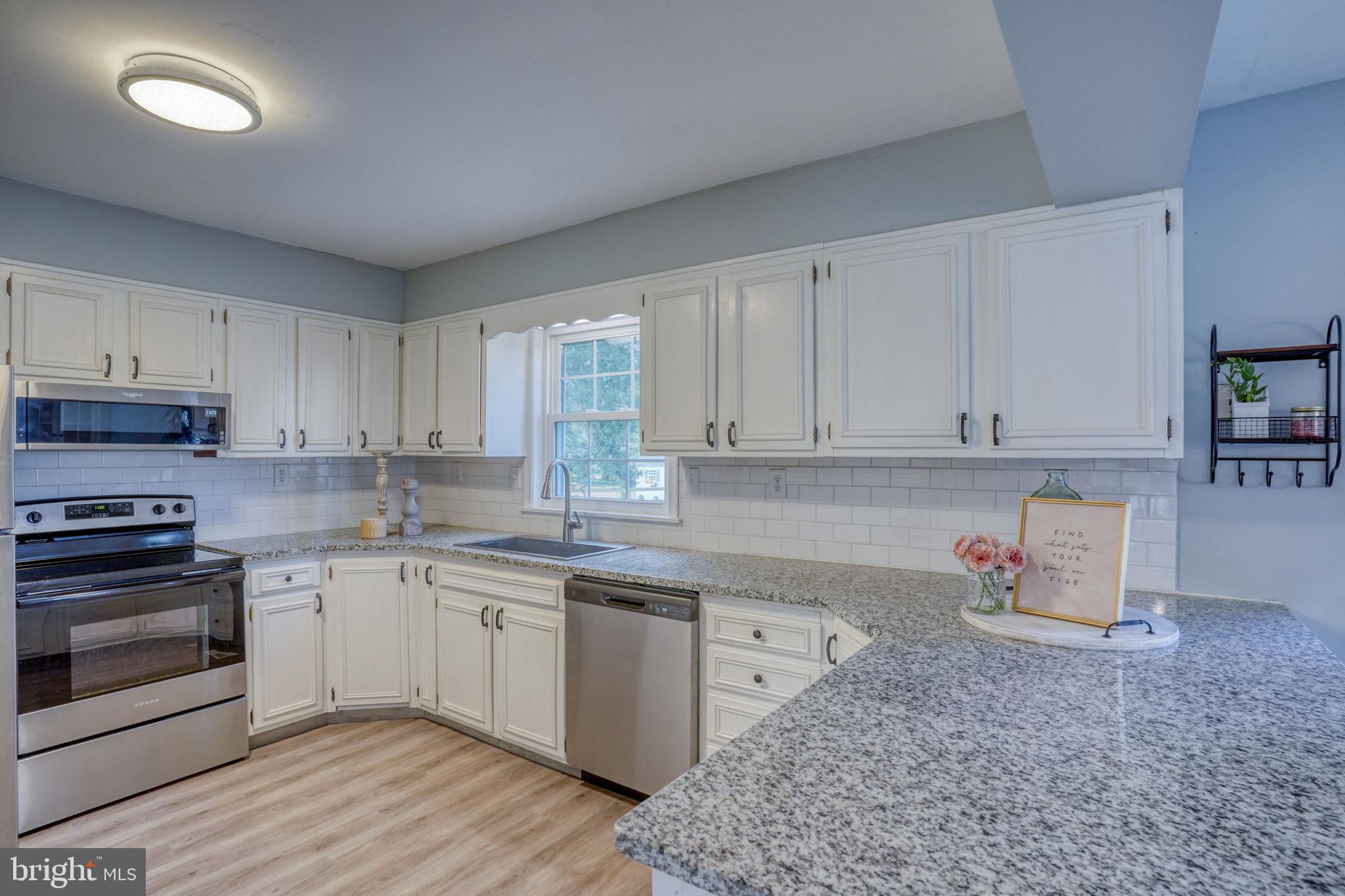 1549 Persimmon Tree Lane Dover, DE 19901 - Photo 8 of 25 a kitchen with stainless steel appliances granite countertop a stove a sink and a refrigerator