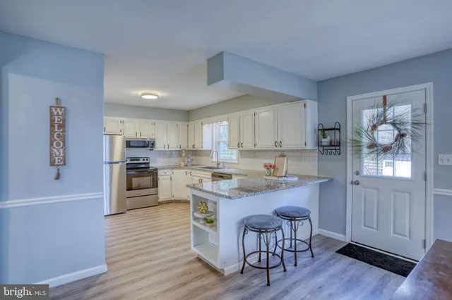 a kitchen with white cabinets and appliances
