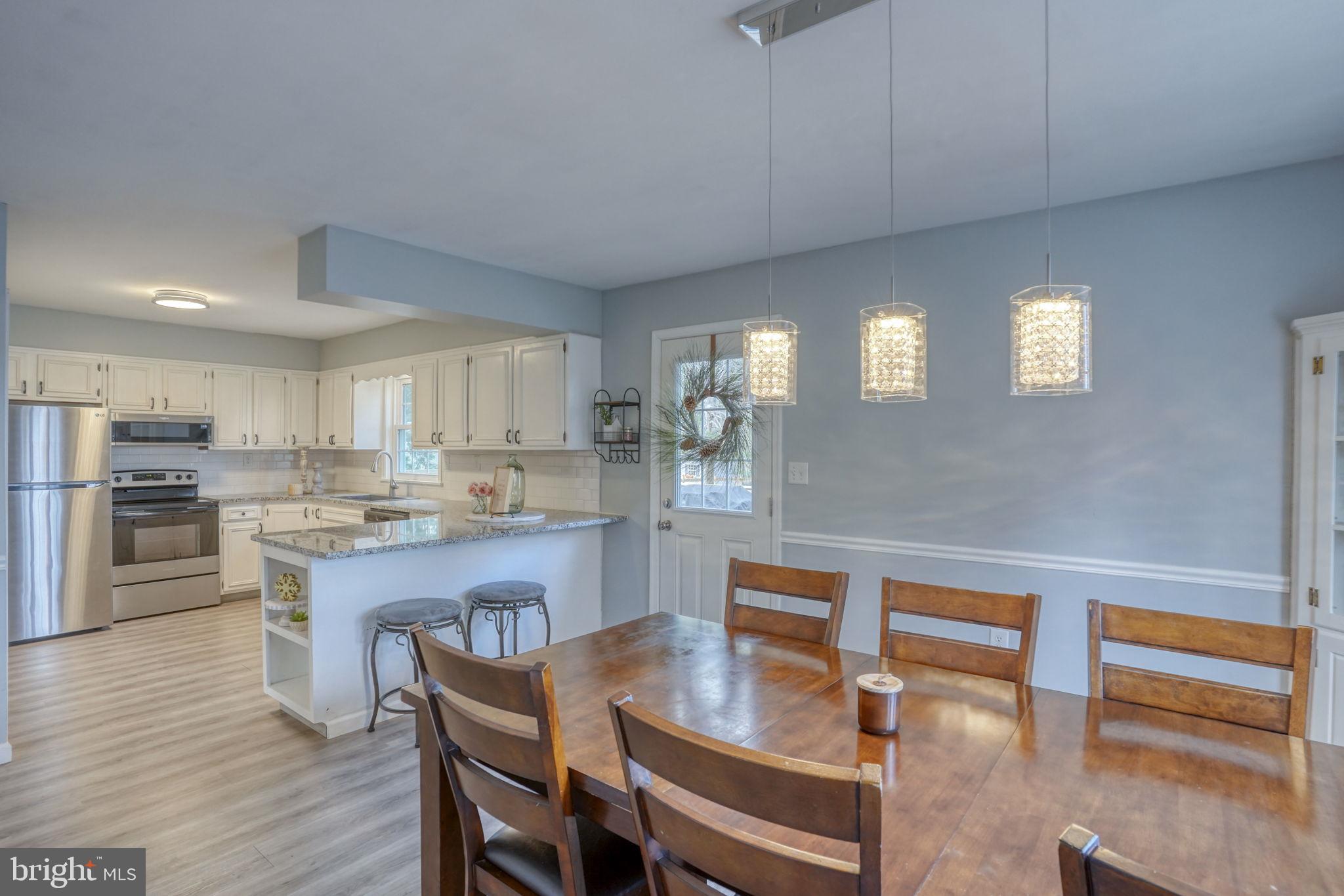 1549 Persimmon Tree Lane Dover, DE 19901 - Photo 10 of 25 a kitchen with stainless steel appliances granite countertop a kitchen island hardwood floor sink stove dining table and chairs