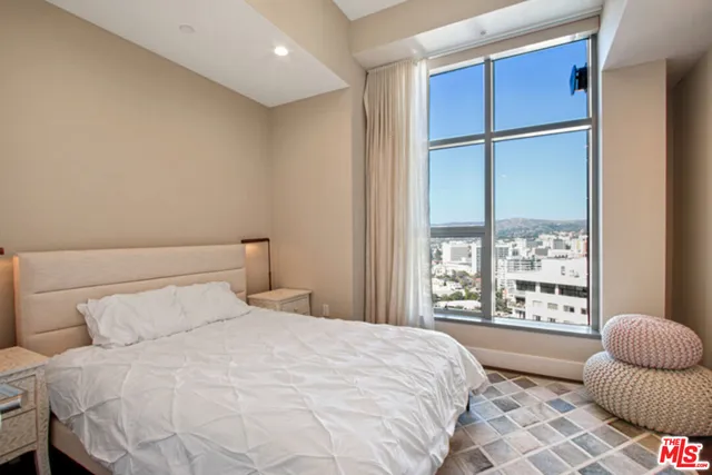 a bedroom with a bed and a large window