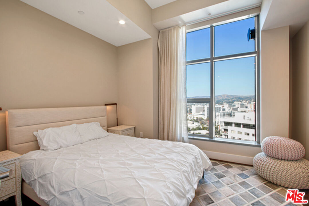 10776 Wilshire Boulevard, Unit 1801 Los Angeles, CA 90024 - Photo 6 of 15 a bedroom with a bed and a large window
