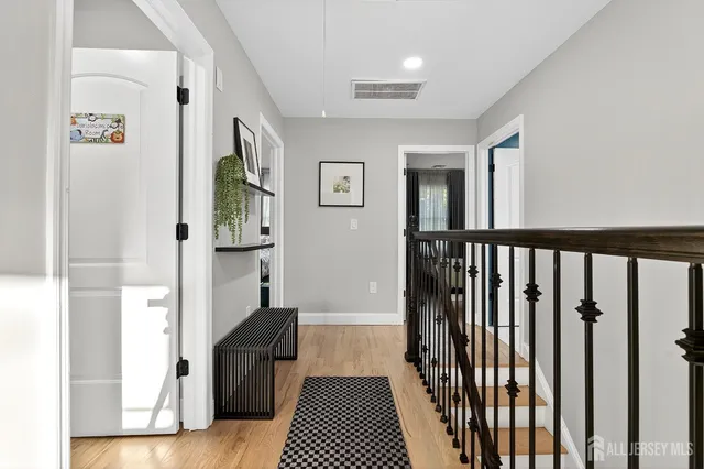 a view of a hallway with wooden floor and windows