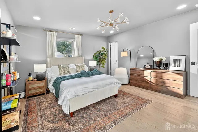 a bed room with a bed mirror and a chandelier