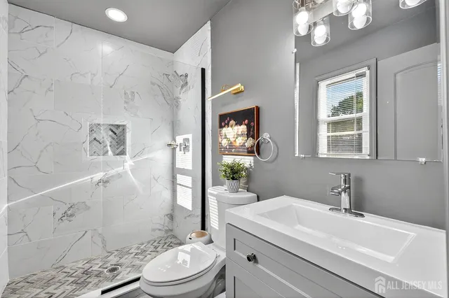 a bathroom with a sink a toilet and shower